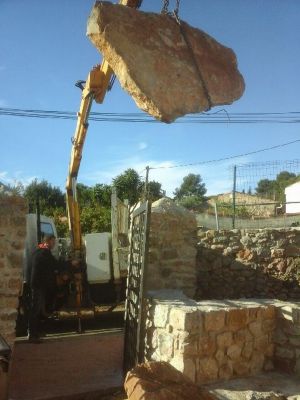 Pose des pierres plates de renfort pour la reconstruction d' un vieux mur au chateau féodal d' ollioules